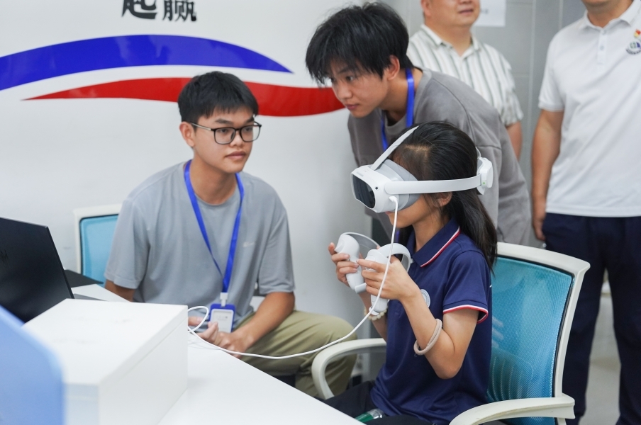 世界杯官网信息工程学院学生正在指导研学团成员体验VR游戏。